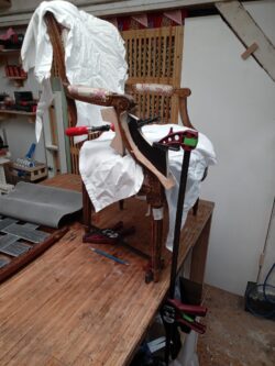 Restauration et recollage d'un pied de fauteuil Louis XVI dans un atelier artisanal au cœur de Paris dans le XIIIe arrondissement