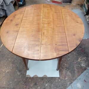 Deuxième couche de protection avant la finition Restauration d'une table en noyer dans un atelier d'ébéniste et de menuisier à Paris, fait à la main, travail de finition, vernis, travail artisanal, travail du bois à Paris